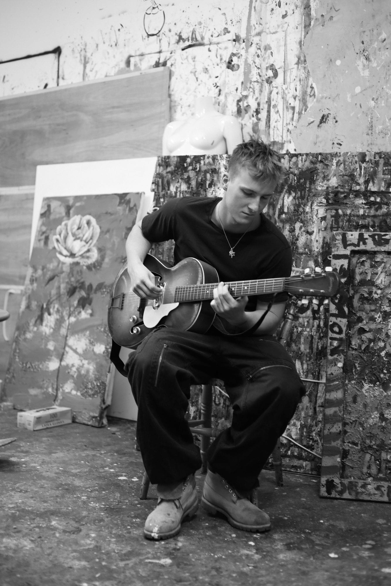 Jesse Grylls playing guitar in his studio